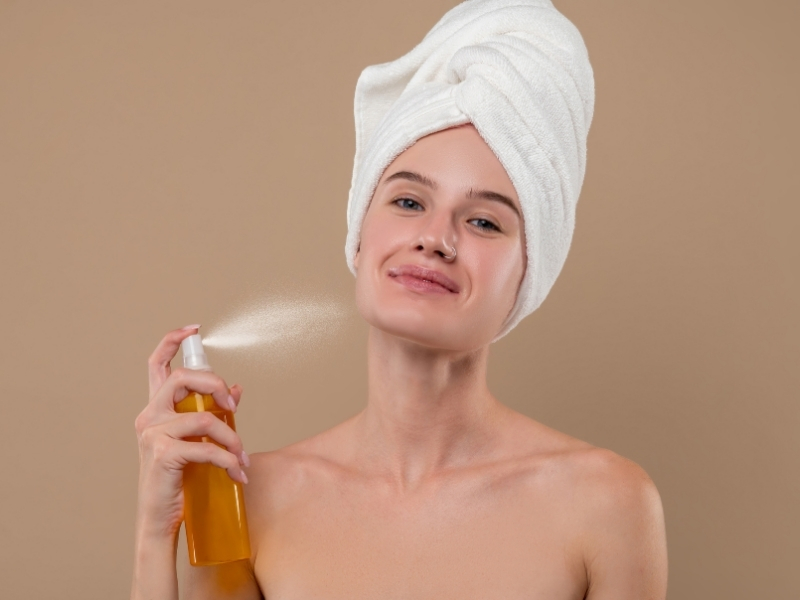 woman hydrating her skin with a mist