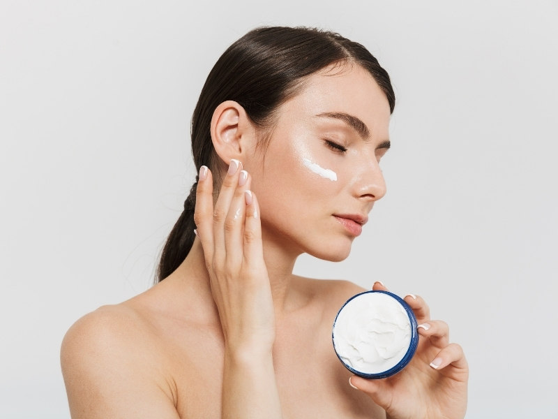 woman applying moisturizer to her face