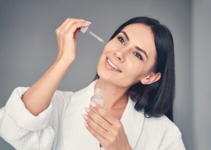 Woman applying night serum for glowing skin.