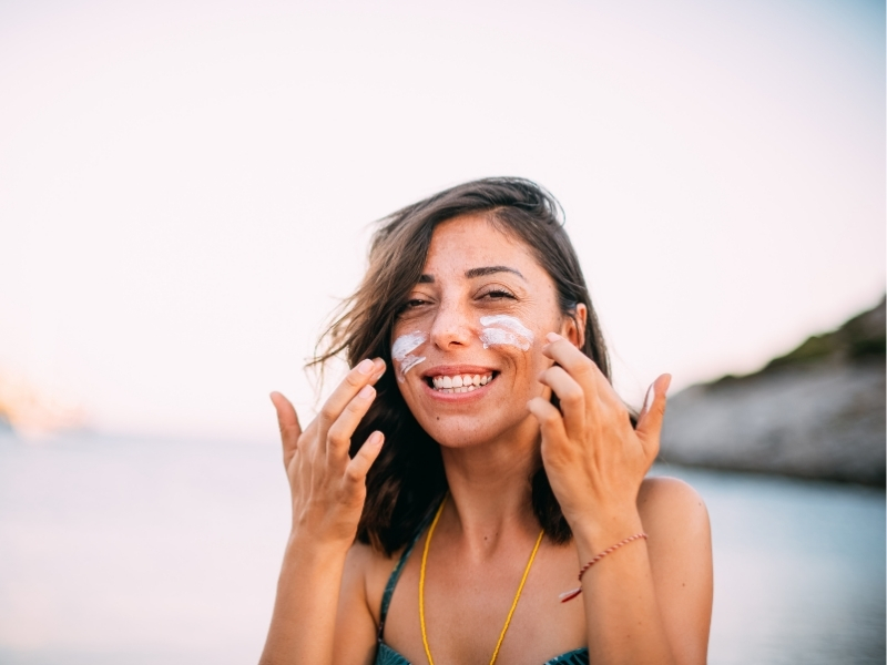 woman applying sunscreen on a cloudy day