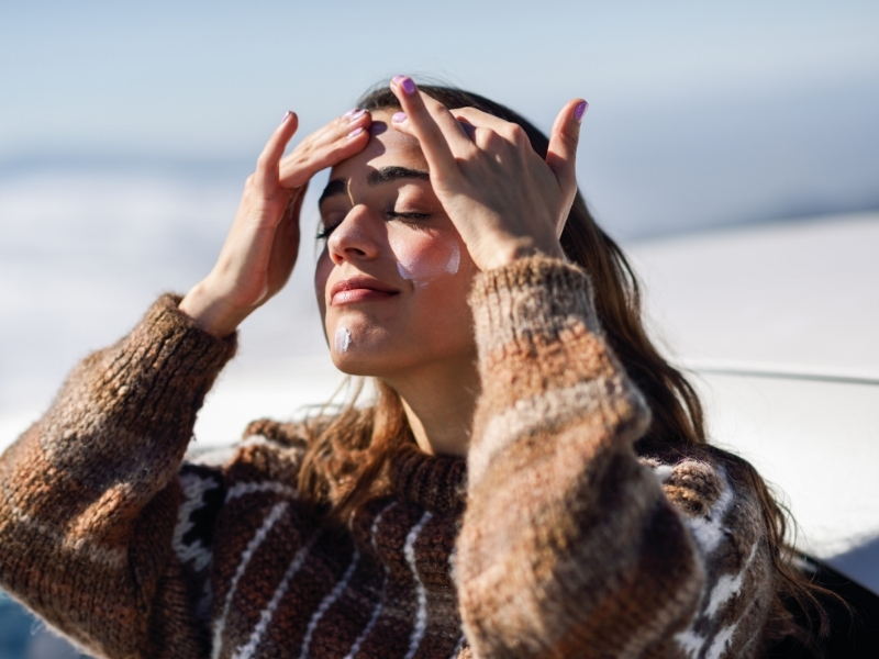 woman applying sunscreen in winter