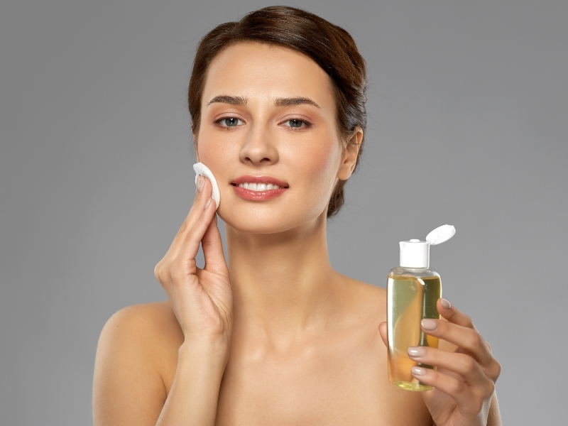 woman applying toner to face