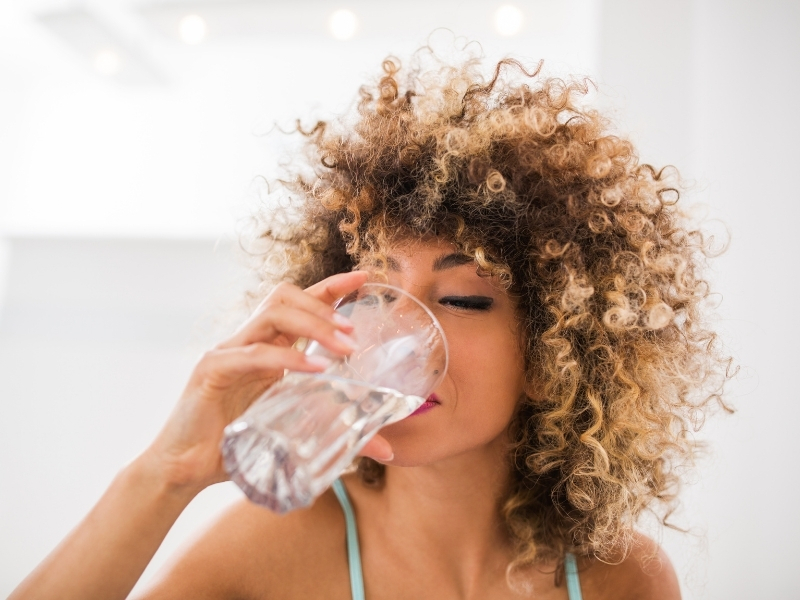 woman drinking water for hydrated skin