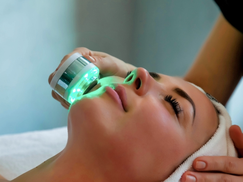 woman using green light therapy for redness