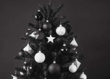 Aesthetic black Christmas tree adorned with white and black geometric ornaments, creating a modern holiday decor theme.