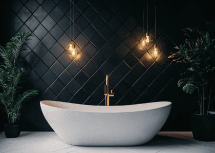 "Modern bathroom featuring black wall tiles, white floor tiles, a centrally placed bathtub, geometric patterned walls, dark gold light fixtures, and decorative plants for a minimalistic design."