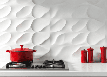 Alt text: "White kitchen featuring a red pot and pan on the stovetop, with a three-dimensional organic-shaped wall panel backsplash, designed for home interior inspiration."